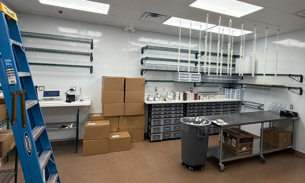 Bakery preparation area for Nothing Bundt Cakes featuring metal shelves, storage boxes, and a worktable, highlighting Kinetic Builders Corp's focus on efficient retail tenant build-outs.