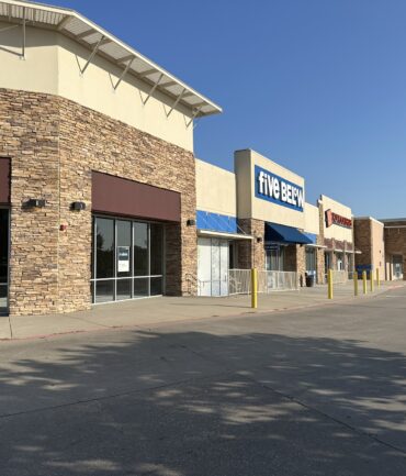Commercial building exterior featuring stone facade and signage for "five BEER" and adjacent businesses, showcasing Kinetic Builders Corp's construction work in retail development.