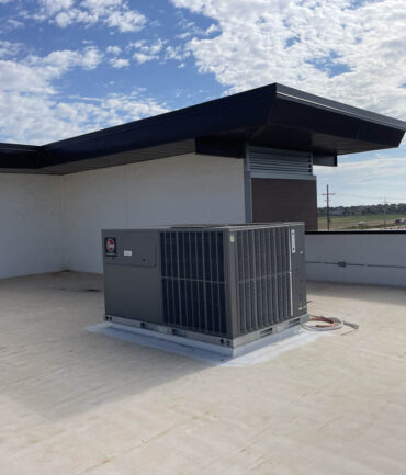 Commercial rooftop HVAC unit installed on a flat roof, showcasing Kinetic Builders Corp's commitment to quality construction in commercial projects.