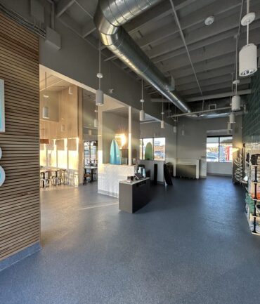 Modern commercial interior showcasing a spacious restaurant environment with sleek design elements, featuring a reception area, decorative glass accents, and ample natural light.