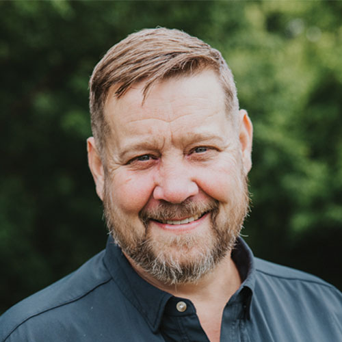Aaron Knapp, CEO and Founding Partner of Kinetic Builders Corp, smiling outdoors, showcasing leadership in commercial construction.