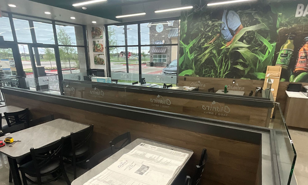 Cilantro’s Taco Bar interior featuring modern design elements, open seating area, and vibrant wall mural, emphasizing fast-casual dining experience in Celina, TX.