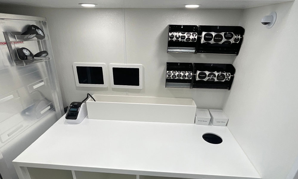 Counter workspace in Crumbl Cookies build-out featuring order processing equipment, menu display screens, and organized supply storage for efficient food retail operations.