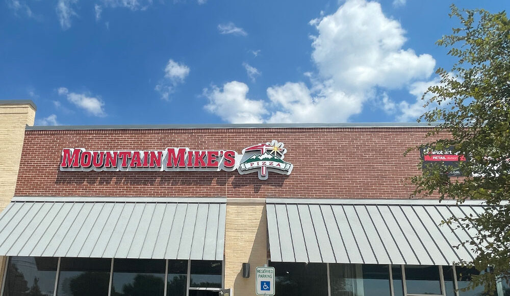 Mountain Mike's Pizza storefront featuring the brand logo and signage, emphasizing retail construction by Kinetic Builders Corp.