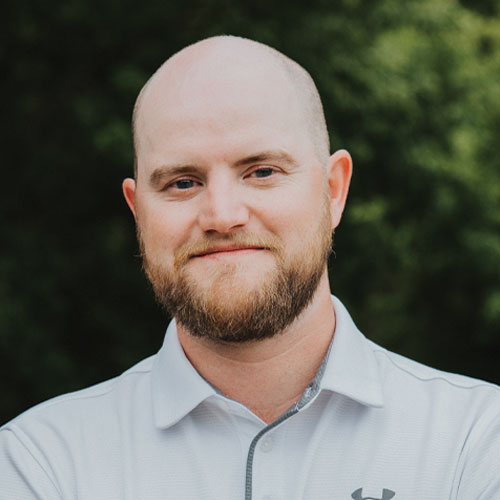 Joe Ellis, President and Founding Partner of Kinetic Builders Corp, smiling and dressed in a light-colored polo shirt, representing leadership in commercial construction.