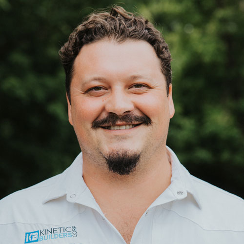 Jordan Fisher, Field Operations Manager at Kinetic Builders Corp, smiling in a branded shirt, with a blurred green background.