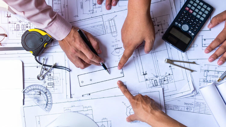 Hands analyzing architectural blueprints and construction plans with measuring tools and a calculator, reflecting innovative restaurant construction techniques.